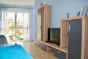 a living room with a tv and a entertainment center at Classy Apartments in Denia