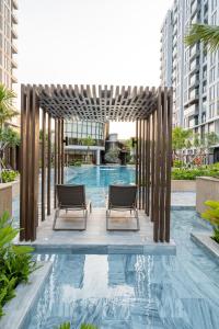 a swimming pool with two chairs in a building at Cardinal Court Phu My Hung near SECC & Crescent in Ho Chi Minh City