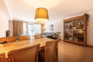 ein Wohnzimmer mit einem großen Holztisch und Stühlen in der Unterkunft Appartement Knokke-Heist in Knokke-Heist