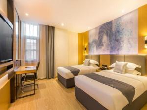 ein Hotelzimmer mit 2 Betten und einem Flachbild-TV in der Unterkunft GreenTree Eastern Hotel Tianjin Dongli Development Zone Xinli Metro Station in Luotuofangzi