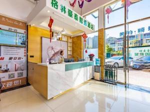 a fast food restaurant with a woman standing at a counter at GreenTree Inn Express Kunming East Passenger Station Huazhicheng in Kunming