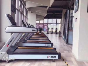 a treadmill in a gym with several treadmills at GreenTree Inn Express Kunming East Passenger Station Huazhicheng in Kunming