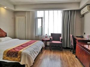 a hotel room with a bed and a desk and a chair at Super 8 Hotel Jinan West Gate of Long Distance Bus Station in Beiyuan