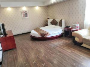 a bedroom with a bed and a couch in a room at Super 8 Hotel Jinan West Gate of Long Distance Bus Station in Beiyuan