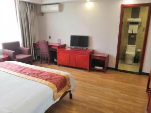 um quarto com uma cama, uma secretária e uma televisão em Super 8 Hotel Jinan West Gate of Long Distance Bus Station em Beiyuan