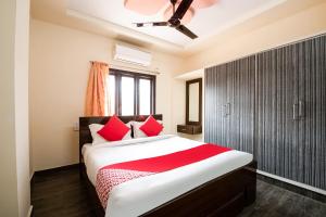 a bedroom with a large bed with red pillows at OYO Seera Enclave in Rājahmundry