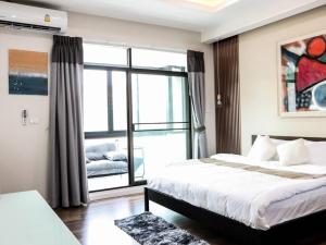 a bedroom with a bed and a large window at Oliver s house in Bangkok