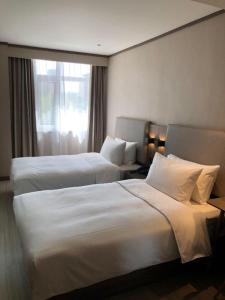 Un pat sau paturi într-o cameră la Hanting Hotel Urumqi Zhongyinggongdi Metro Station