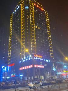 Ji Hotel Jinan 2nd Ring Xi Road في Luokou: مبنى كبير مع أضواء عليه في الليل