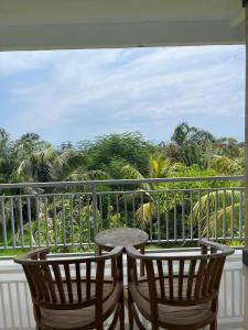 a balcony with two chairs and a table at Azona Greens Uluwatu in Uluwatu