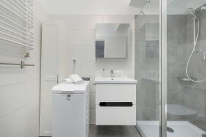 ein weißes Bad mit einem Waschbecken und einer Dusche in der Unterkunft Unique Apartments in Szczecin by Rent like home in Stettin