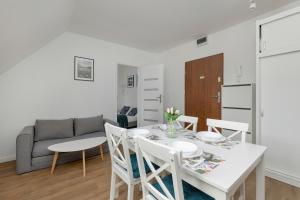 ein Esszimmer mit einem Tisch, Stühlen und einem Sofa in der Unterkunft Unique Apartments in Szczecin by Rent like home in Stettin