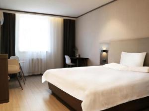 Un pat sau paturi într-o cameră la Hanting Hotel Jinan West Market