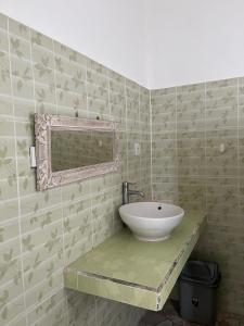 a bathroom with a sink on a tiled wall at Azona Greens Uluwatu in Uluwatu