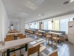 uma sala de jantar com mesas e cadeiras num edifício em Hanting Hotel Wuhan Xinhua Road Xiehe Hospital em Wuhan