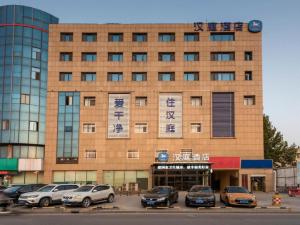 un edificio con coches estacionados frente a él en Hanting Hotel Jinan Guo Branch, en Jinan