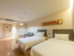 Hanting Hotel Jinan Guo Branch في جينان: غرفة فندقية بسريرين وكرسي
