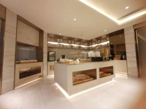 Ji Hotel Wuxi Shuofang Airport في Daqiangmen: مطبخ مع كونتر مع الكعك فيه