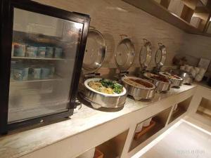 Ji Hotel Wuxi Shuofang Airport في Daqiangmen: مطبخ مع عدة قدور من الطعام على منضدة