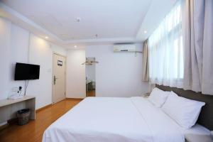 a bedroom with a white bed and a television at Hi Inn Nanjing Youfang Bridge Metro Station in Shazhou