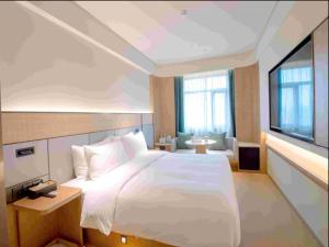 Ji Hotel Shanghai Tang Bridge Shimao Riverside tesisinde bir odada yatak veya yataklar
