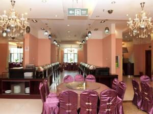 une salle à manger avec des chaises violettes et une table dans l'établissement Starway Hotel Ha'Erbin Convention And Exhibition Center, à Harbin