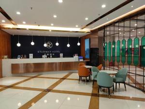 eine Lobby mit einem Tisch, Stühlen und einer Theke in der Unterkunft Starway Hotel Ha'Erbin Convention And Exhibition Center in Harbin
