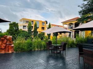 een patio met een tafel met stoelen en een parasol bij Precious Villas Lubowa in Kampala