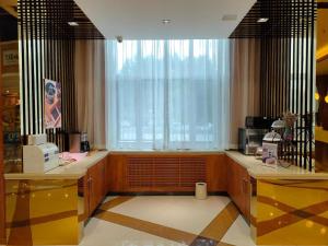 eine Küche mit einem Fenster und einer Theke mit einer Mikrowelle in der Unterkunft Starway Hotel Ha'Erbin Convention And Exhibition Center in Harbin