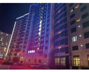 Un grand bâtiment est éclairé la nuit. dans l'établissement Starway Hotel Ha'Erbin Convention And Exhibition Center, à Harbin
