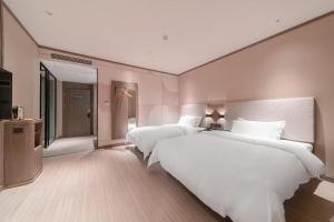 سرير أو أسرّة في غرفة في Hanting Hotel Wuhan Xudong Shopping Mall