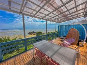 eine Terrasse mit einem Tisch, Stühlen und Meerblick in der Unterkunft Repos Terrace - Vacation STAY 97966v in Amami