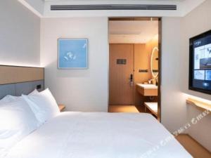 Ένα ή περισσότερα κρεβάτια σε δωμάτιο στο Ji Hotel Jiaxing Shanshan Impression Plaza