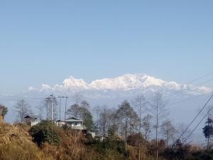 a mountain with snow capped mountains in the distance w obiekcie The hotel mountain Taplejung w mieście Tāplejung