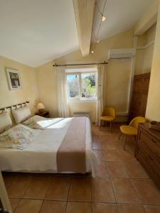 Un dormitorio con una cama grande y una ventana en Le Mazet des Mûres, en Grimaud