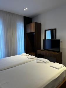1 dormitorio con 2 camas y TV de pantalla plana en 4 Stinët, en Valbonë