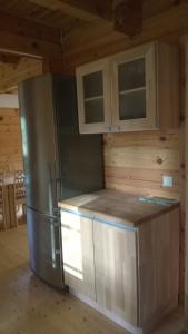 kuchnia z lodówką i szafkami ze stali nierdzewnej w obiekcie Peko Holiday Home w mieście Õrsava