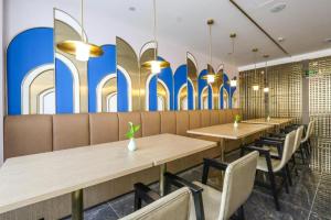 una fila de mesas y sillas en un restaurante en Starway Hotel Hangzhou Yipeng Shopping Center, en Chang-shen-tien