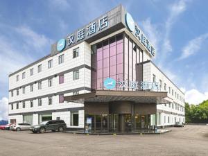 um edifício com um carro estacionado em frente em Hanting Hotel Nanjing Jiangning Binjiang Development Zone Park em Qingxiu