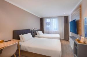 Un pat sau paturi într-o cameră la Hanting Premium Hotel Nanjing Pukou Pudong Road