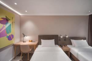 Un pat sau paturi într-o cameră la Hanting Premium Hotel Nanjing Pukou Pudong Road