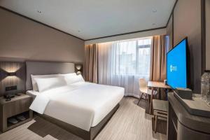 Un pat sau paturi într-o cameră la Hanting Hotel Nanjing Central Gate Xianfeng Square