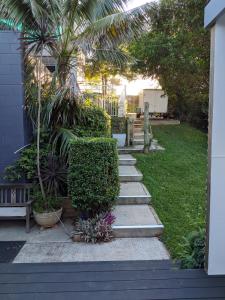 a garden with stairs and plants and a house at Rainforest Cottage in Port Macquarie