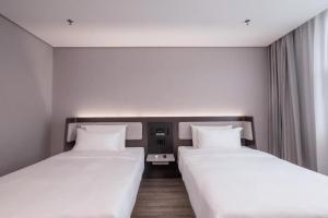 A bed or beds in a room at Hanting Hotel Beijing Dongzhimen
