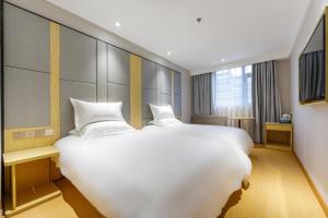 سرير أو أسرّة في غرفة في Hi Inn Shanghai Hongqiao Panyu Road