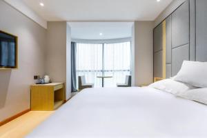 سرير أو أسرّة في غرفة في Hi Inn Shanghai Hongqiao Panyu Road