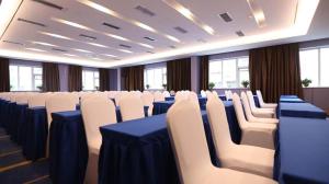 einen Konferenzraum mit weißen Stühlen und blauen Tischen in der Unterkunft Starway Hotel Zhengzhou Jingguang Road Metro Station in Zhengzhou