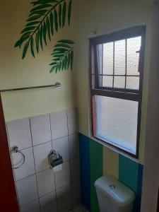 een badkamer met een toilet en een raam bij Lagoon Ndziva, Bilene in Vila Praia Do Bilene