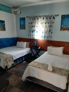 a room with two beds and a window at Lagoon Ndziva, Bilene in Vila Praia Do Bilene