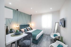 Schlafzimmer mit einem Bett, einem Tisch und Stühlen in der Unterkunft Apartments Blue Ivy in Zadar